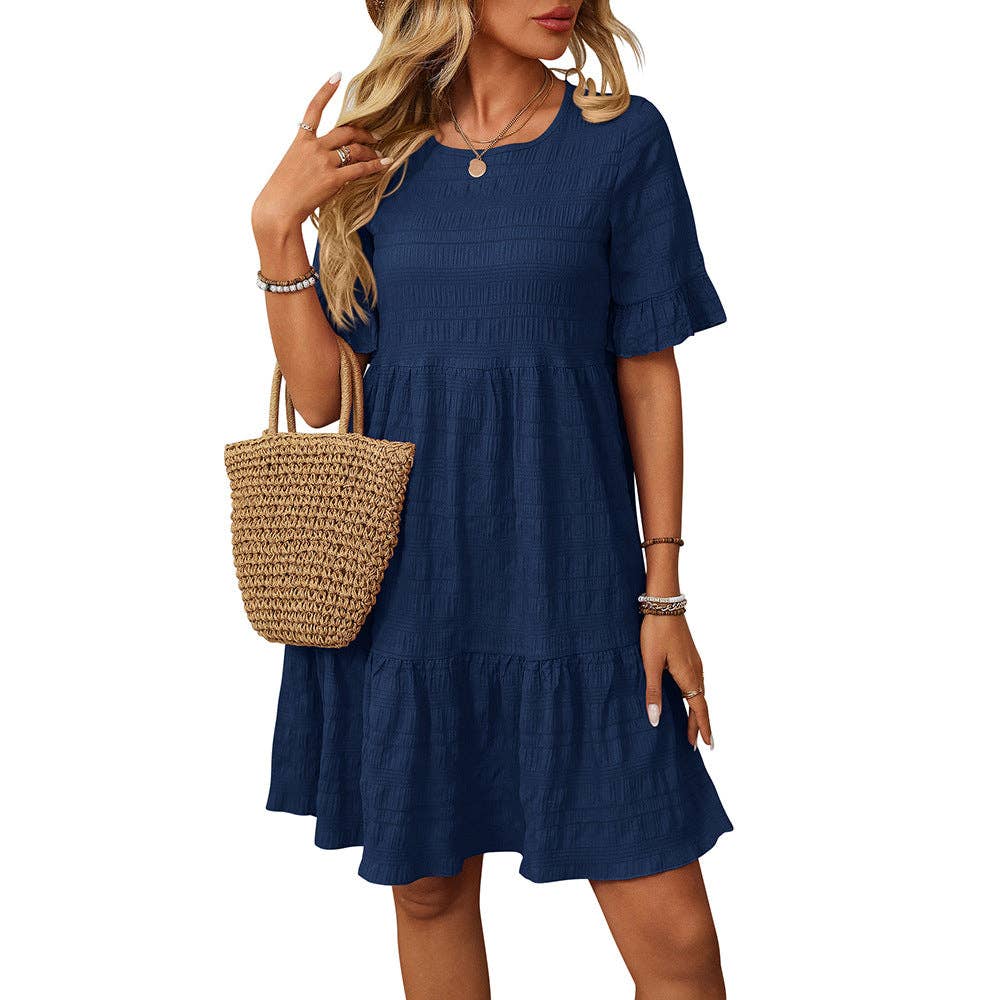 Woman wearing a blue dress holding a straw bag on a white background